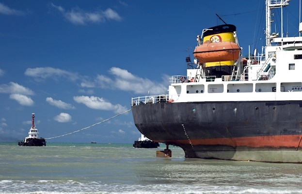 Grounded ship two tugs