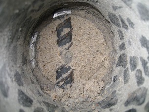 Kerneudboring i søjle viser separeret materiale i korrugeret rør.